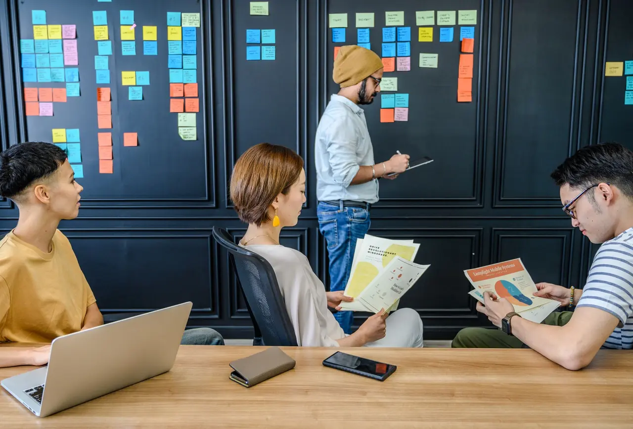 Colleagues planning a campaign in front of a wall of sticky notes