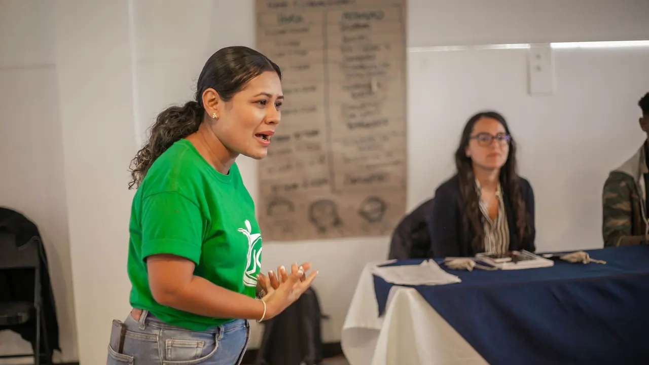 A young woman speaking to neighbors at a community meeting