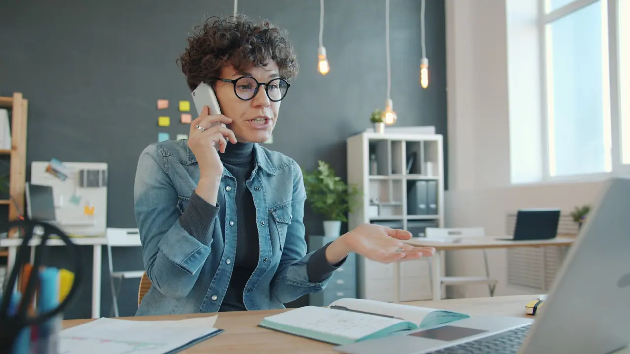 A woman on a phone call at her desk