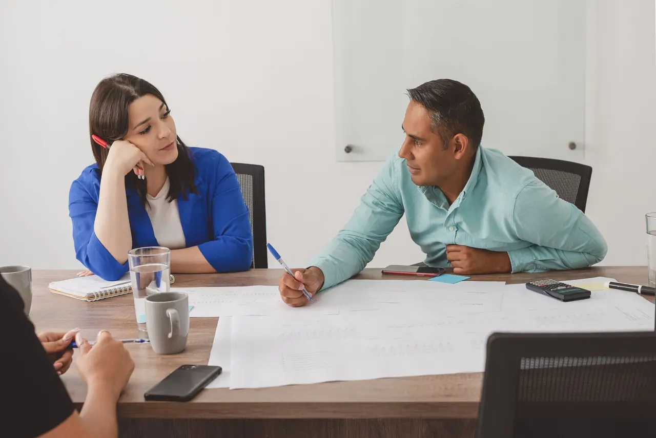 Two professionals reviewing plans and documents together