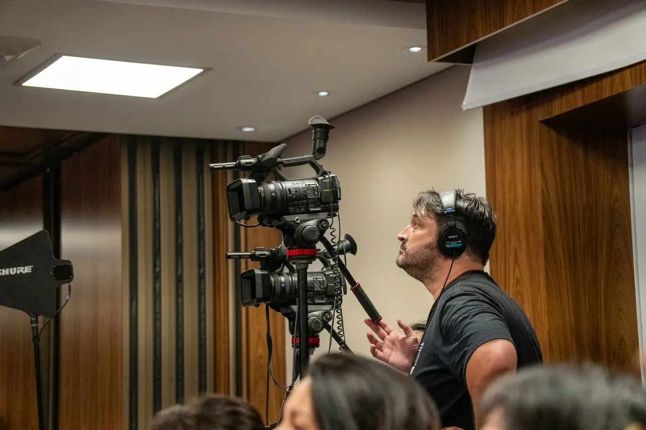 A camera operator recording at a press event